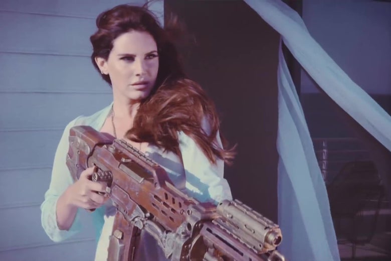 Lana Del Rey, holding a grenade launcher, in the music video for "High by the Beach."